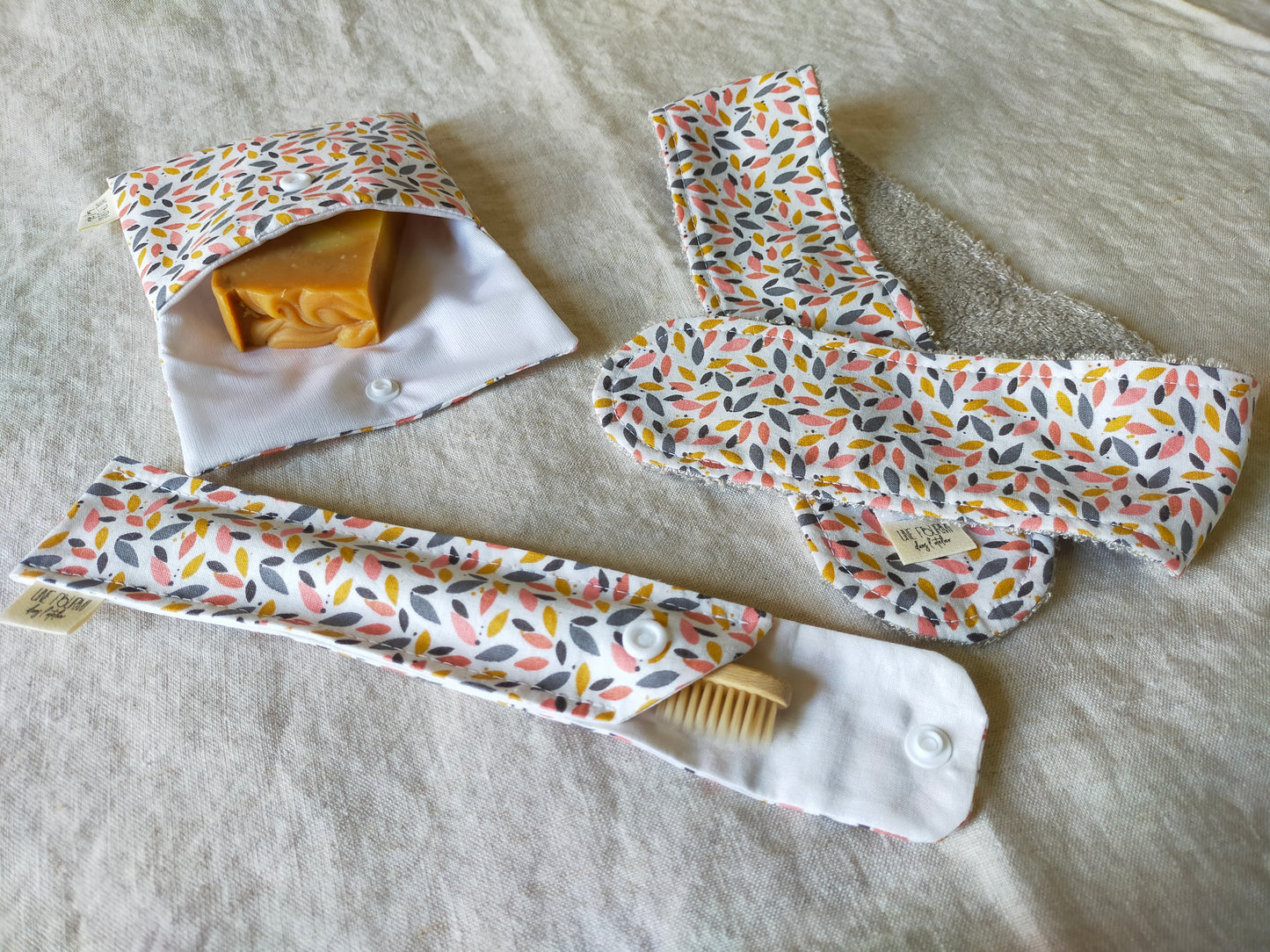 présentation du set de 3 pièces avec la pochette à savon, l'étui brosse à dent et le bandeau de soin, format pratique pour les trousses de toilette.