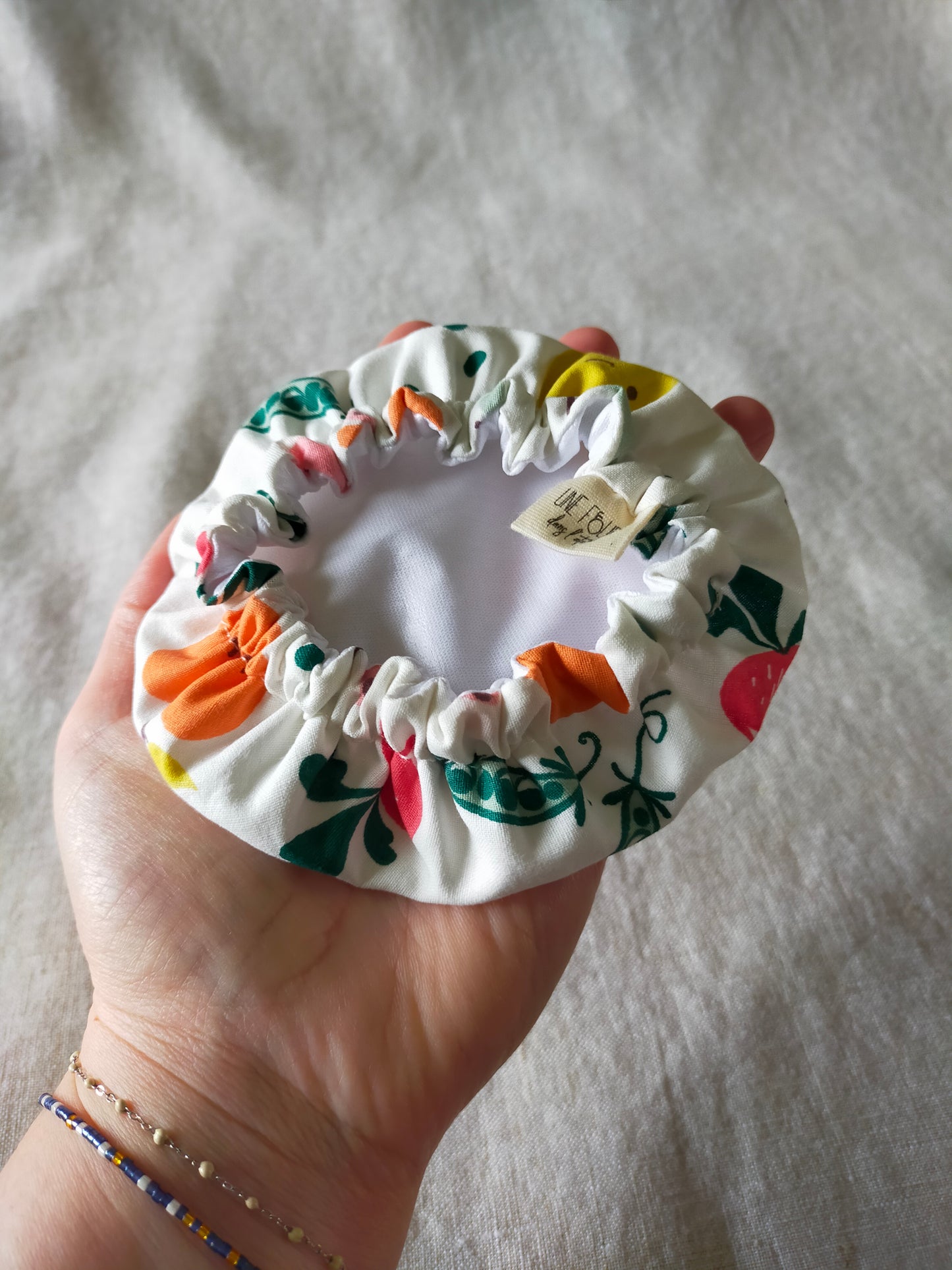 vue de dessous d'une mini charlotte couvre plat avec la doublure en pul blanc.