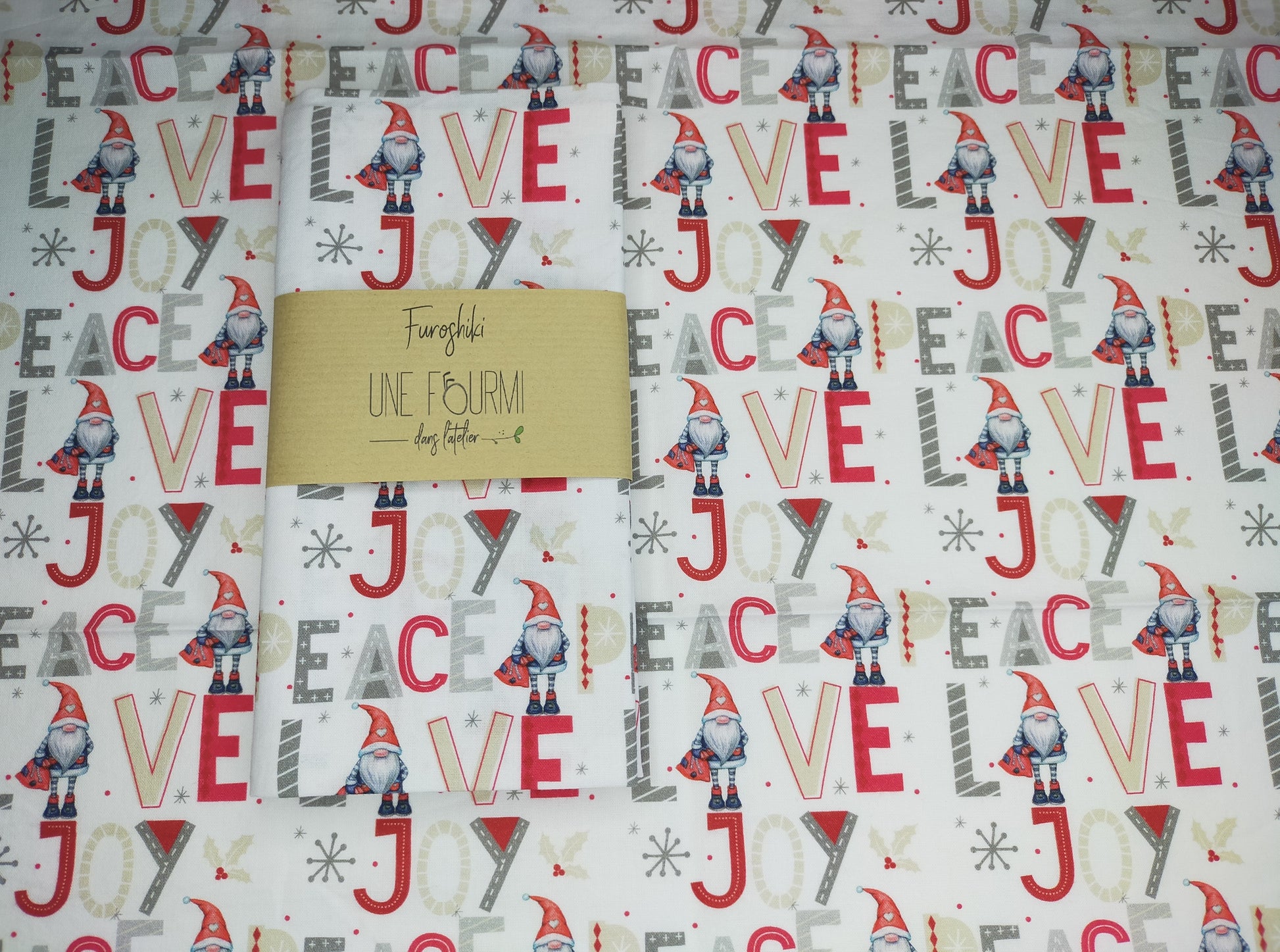 tissu en coton blanc avec lutin de noel et mots peace, love et joy dans les tons rouge, beige, gris