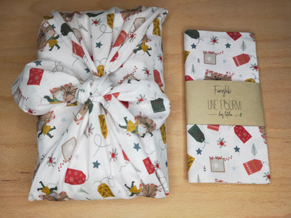 furoshiki sur le thème de Noel avec un tissus en coton sur fond blanc et des motifs d'étiquette de noel et de petites souris dans les tons verts, jaune, blanc et rouge. emballage cadeau réutilisable et lavable, accessoire écologique et zéro déchet.