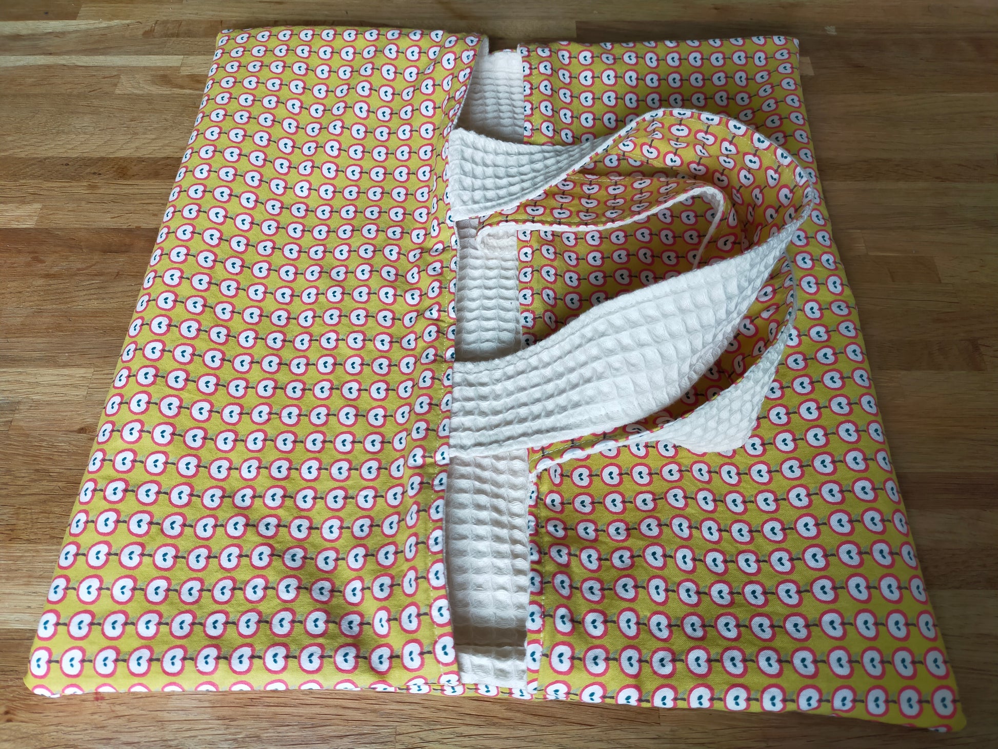 Sac à tarte réversible en coton avec des motifs de pommes et nid d'abeille de couleur écru. Couleur jaune, rouge et blanc