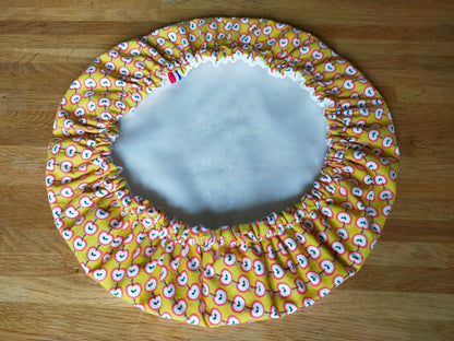 Charlotte couvre plat en coton avec motifs de pommes et doublure en PUL. Couleur jaune, rouge et blanc