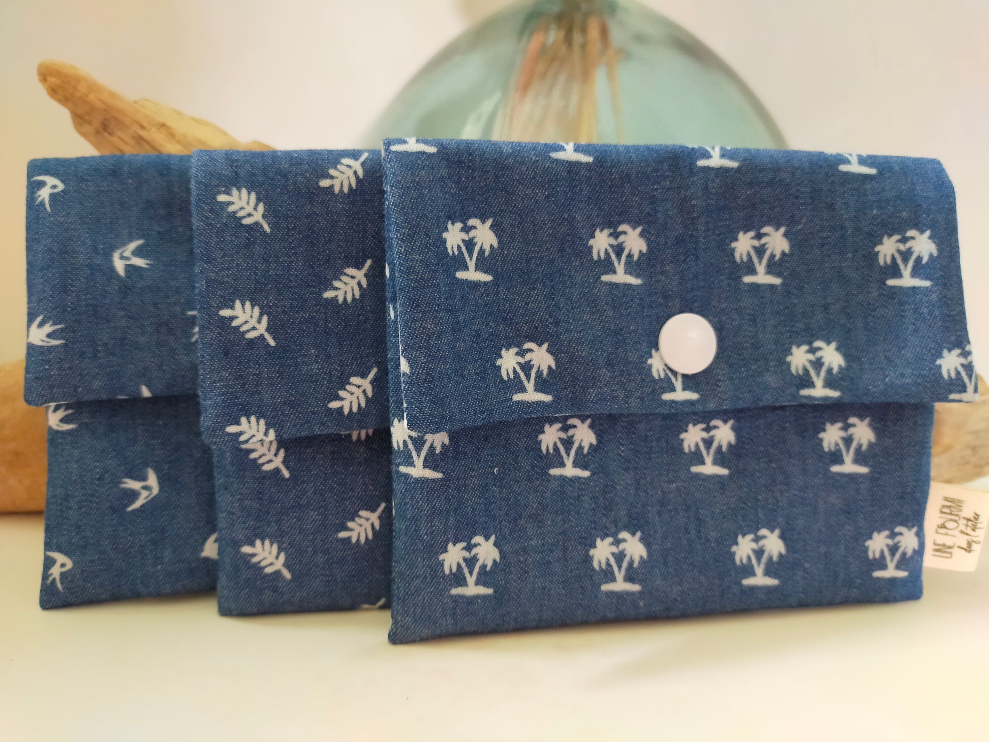 Présentation des différents motifs de pochettes à savon en chambray de coton couleur blue jean: palmiers, oiseaux et fougères