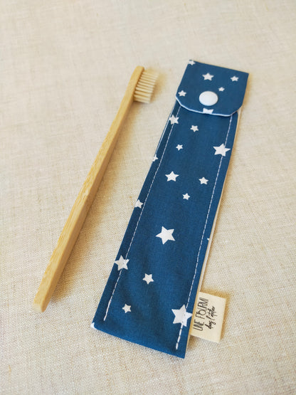 étui pour brosse à dent de couleur bleu  avec des étoiles blanches en motif. accessoire de voyage pratique et utile. accessoire de trousse de toilette.