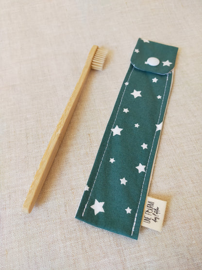 étui pour brosse à dent de couleur vert avec des étoiles blanches en motif. accessoire de voyage pratique et utile. accessoire de trousse de toilette.