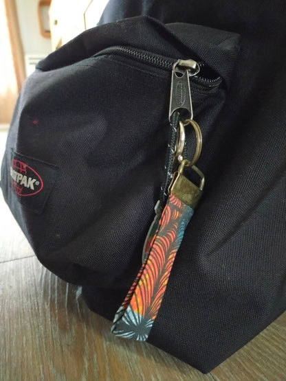 porte clé dragonne attaché au curseur d'une fermeture éclaire sur un sac à dos pour faciliter l'ouverture.