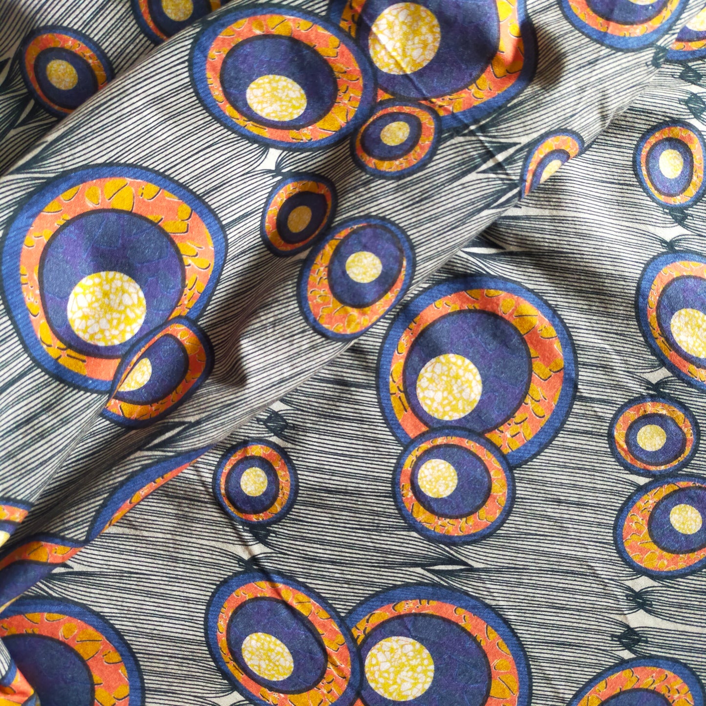 cretonne de coton, styla africain avec es motifs de bulles ou cercles, tons orange, bleu