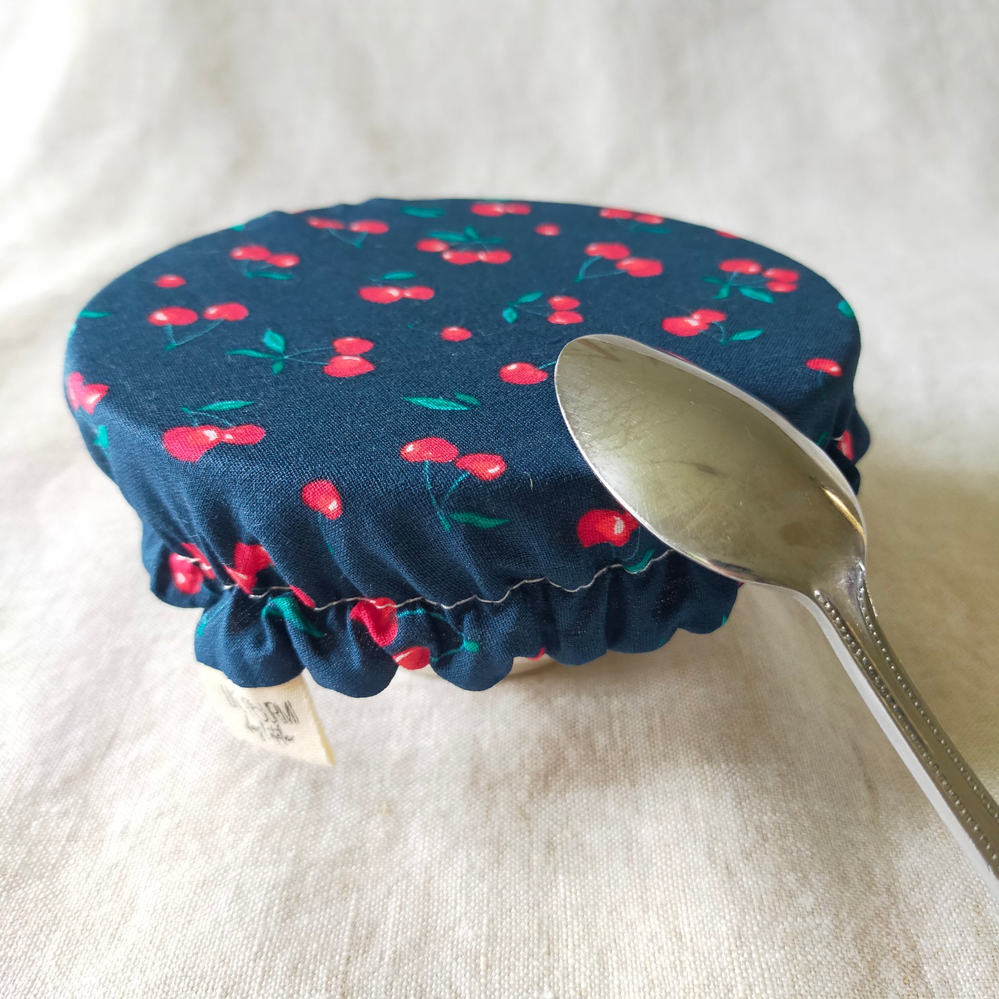 mini charlotte couvre bol pour ramequin et petit récipient de cuisine. accessoire zéro déchet pratique et utile. tissu bleu marine et cerises rouges