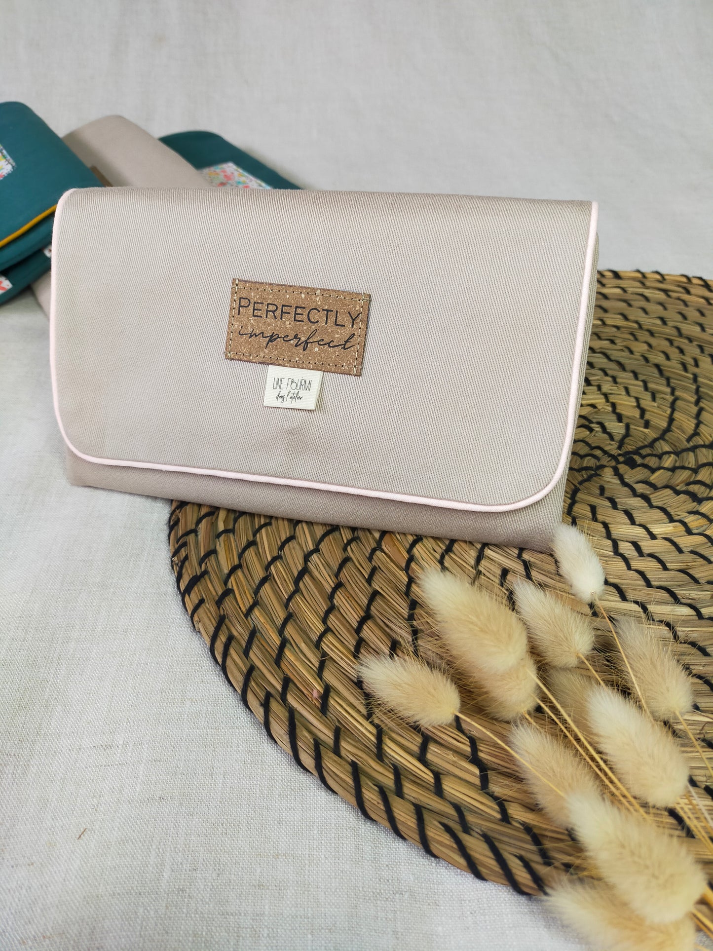 pochette à bijoux fermée. Etiquette en cuir recyclé sur l'avant du rabat avec noté dessus Perfectly imperfect. Etiquette de la marque Une fourmi dans l'atelier insérée dans la couture.