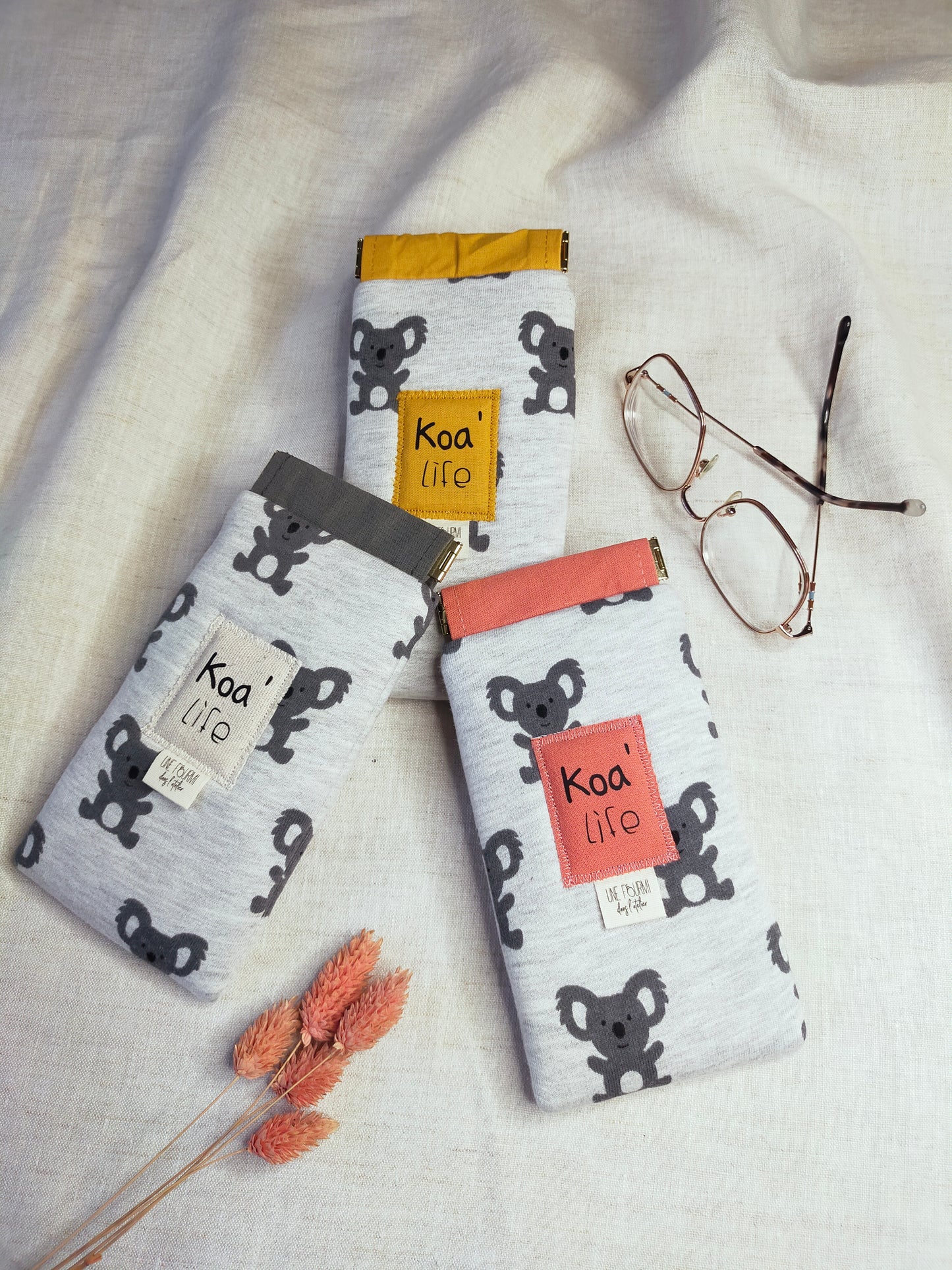 Etui à lunettes pour enfant avec des motifs de Koala gris. 3 modèles différents avec pour couleur de doublure, rose, jaune ou gris.