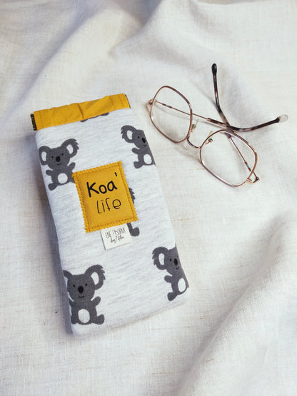 vue dessus, étui à lunette rembourré avec les motifs de Koala et la doublure Jaune. Patch sur l'avant avec inscription Koa'Life