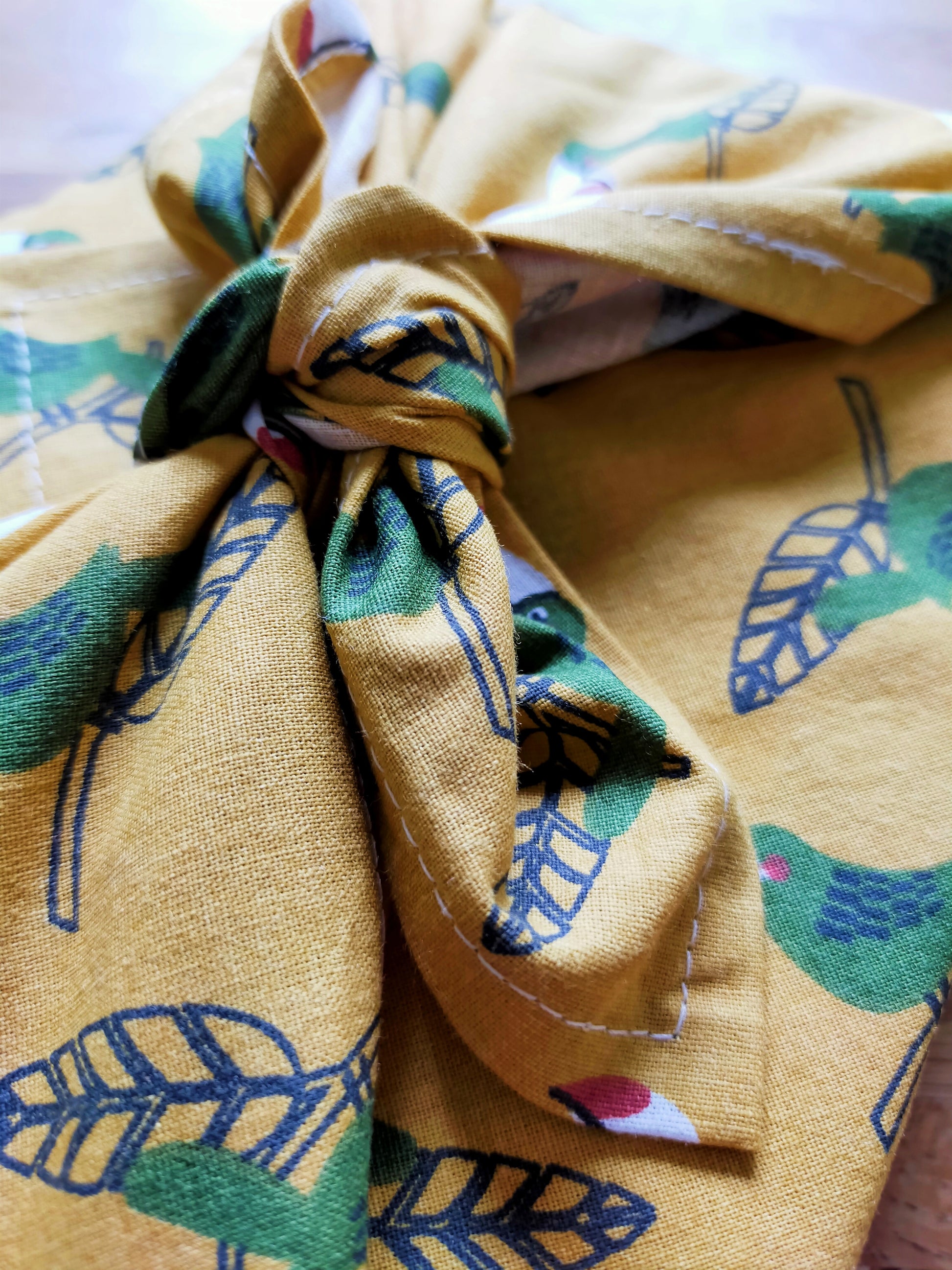 zoom sur le noeud de furoshiki. emballage cadeau simple et rapide, tissu jaune et bleu. accessoire zéro déchet