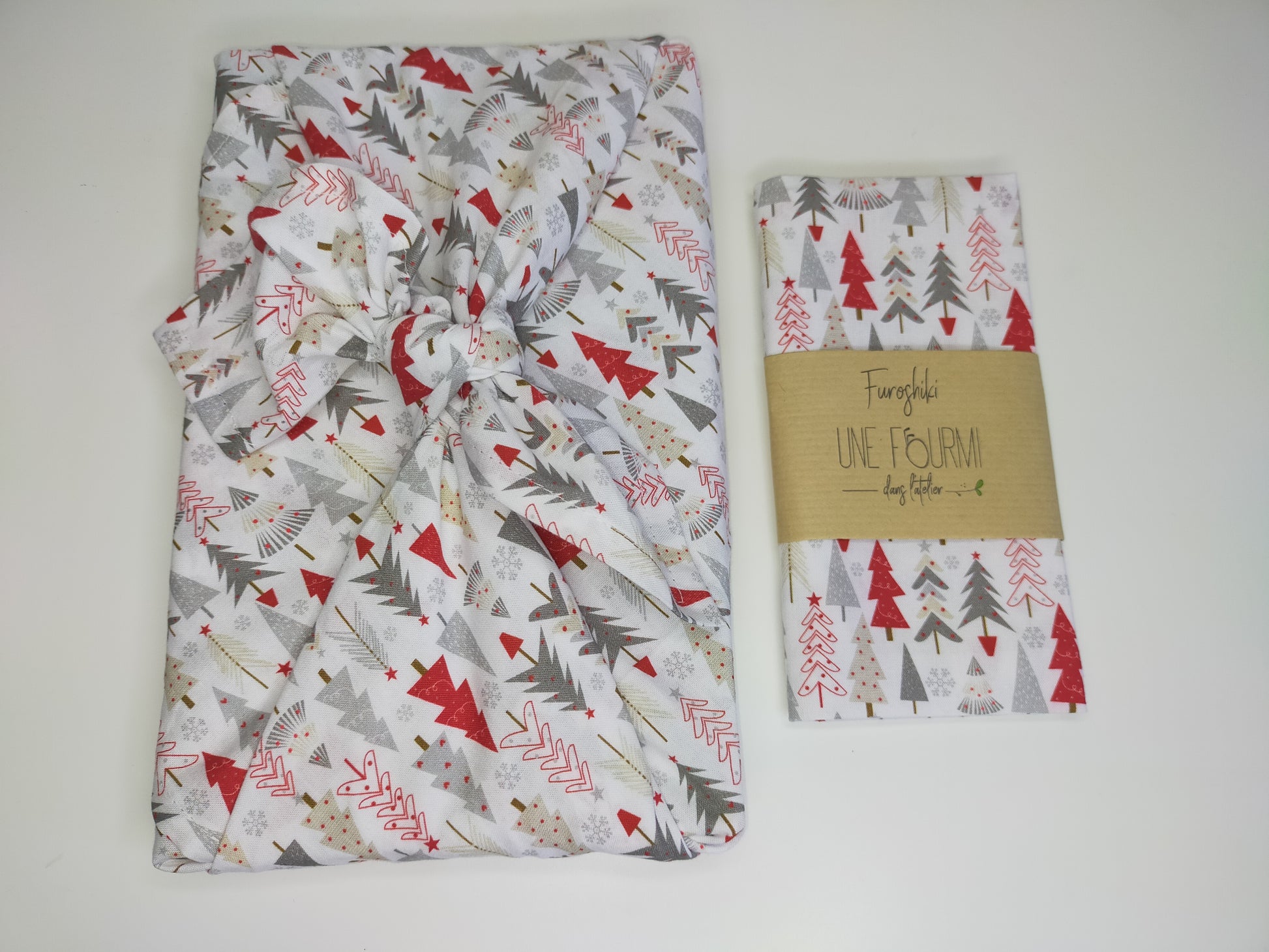 furoshiki sur le thème de Noel dans les tons blanc, rouge et gris avec motifs de sapins. emballage cadeau réutilisable et lavable, accessoire écologique et zéro déchet.