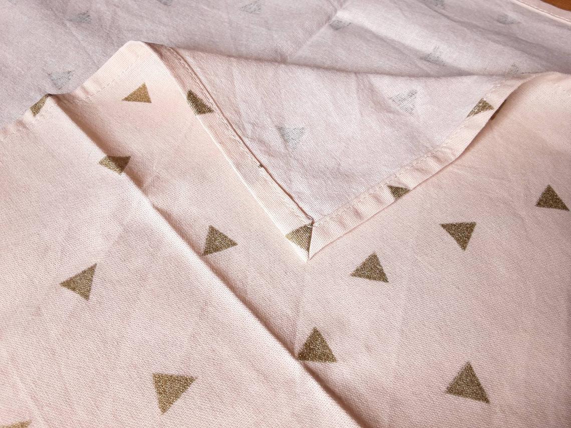 zoom sur couture de furoshiki. tissu coton nude et triangles dorés.