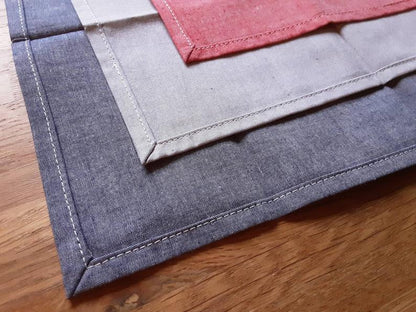 zoom sur les ourlets des mouchoirs de couleur bleu, gris et rouge