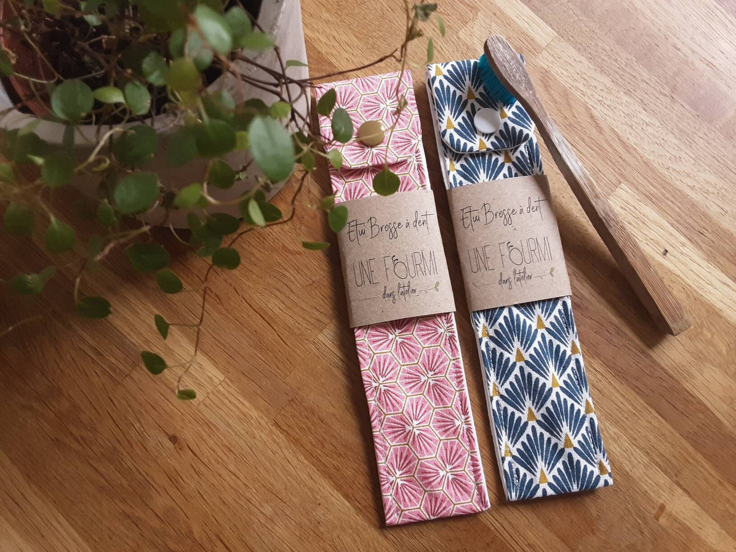 2 étuis à brosse dent, l'un rose avec des écailles en motifs, l'autre bleu aux motifs d'éventails